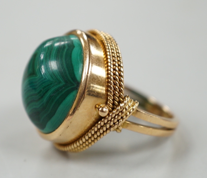 A yellow metal and cabochon malachite set dress ring, size F/G